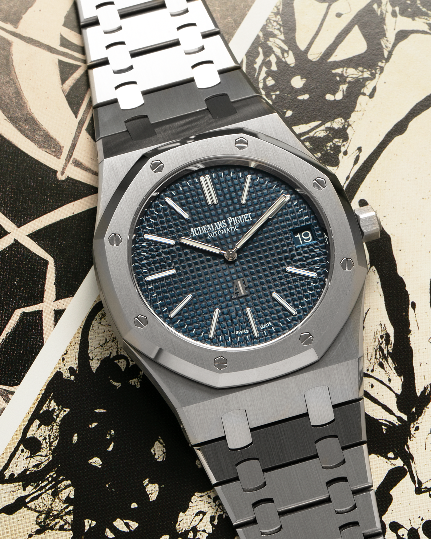 Brand: Audemars Piguet Year: 2022 Model: Royal Oak “Jumbo” Extra-Thin “50th Anniversary” Reference Number: 16202ST.OO.1240ST.01 Material: Stainless Steel Movement: Audemars Piguet Cal. 7121, Self-Winding (Special Engraved Rotor) Case Dimensions: 39mm x 8.1mm Bracelet: Audemars Piguet Stainless Steel Integrated Bracelet