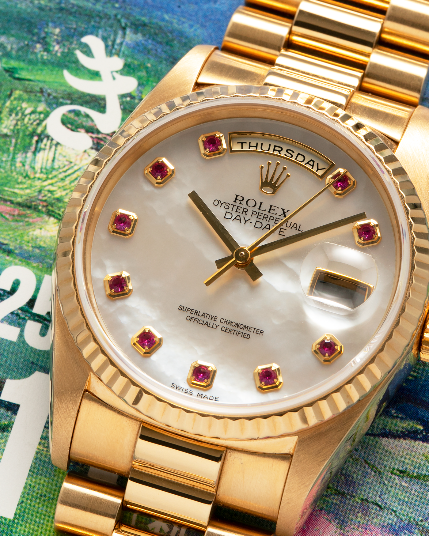 Brand: Rolex
Year: 1989
Model: Day-Date ‘Mother-of-Pearl Rubies’
Reference Number: 18238
Serial Number: L980XXX
Material: 18-carat Yellow Gold
Movement: Rolex Cal. 3155, Self-Winding
Case Dimensions: 36mm x 12mm (Lug-to-Lug 43.7mm)
Lug Width: 20mm
Bracelet: Rolex 18-carat Yellow Gold ‘8385’ Presidential Bracelet with 55B Curved End Links and Signed ‘O5’ Folding Clasp