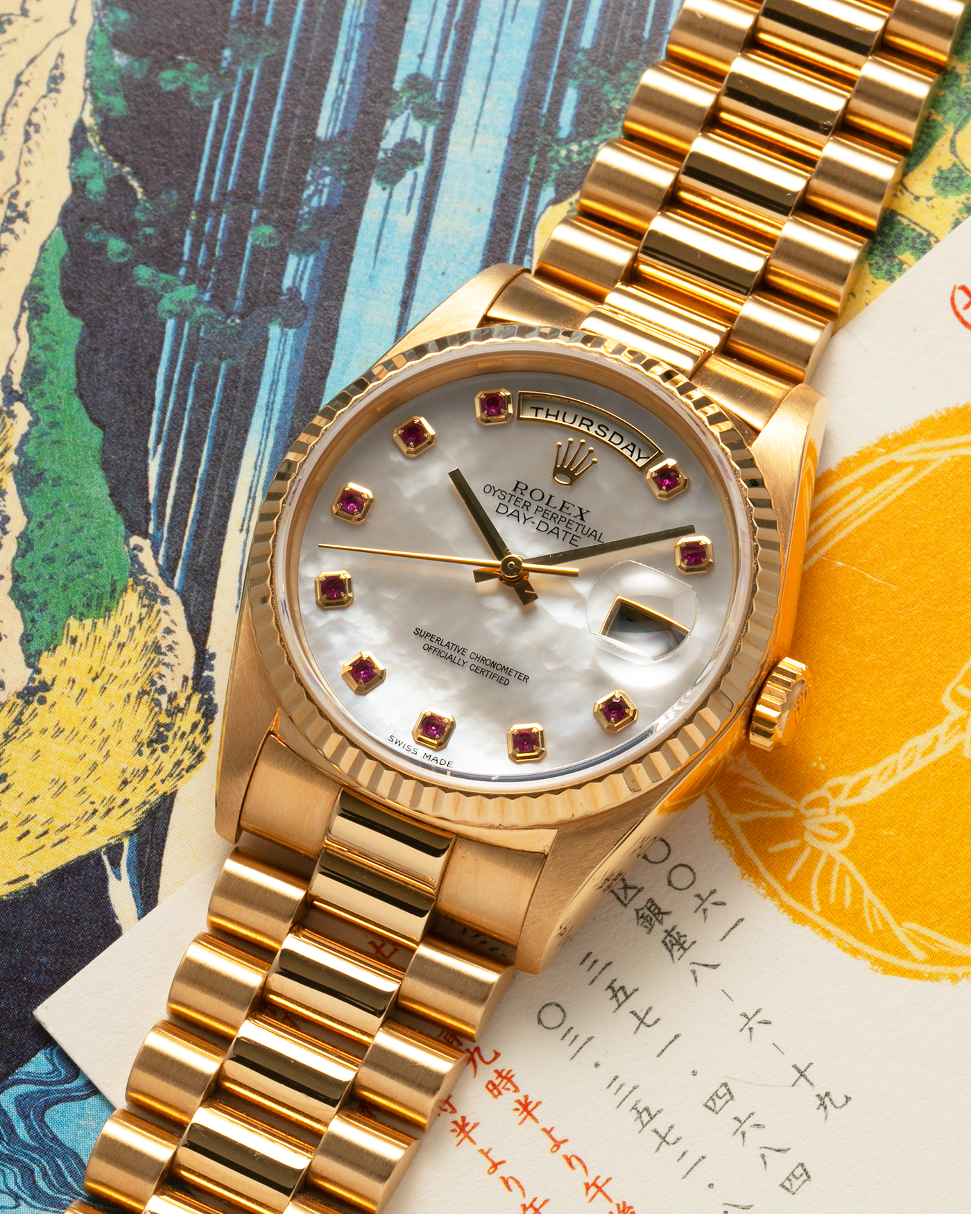 Brand: Rolex
Year: 1989
Model: Day-Date ‘Mother-of-Pearl Rubies’
Reference Number: 18238
Serial Number: L980XXX
Material: 18-carat Yellow Gold
Movement: Rolex Cal. 3155, Self-Winding
Case Dimensions: 36mm x 12mm (Lug-to-Lug 43.7mm)
Lug Width: 20mm
Bracelet: Rolex 18-carat Yellow Gold ‘8385’ Presidential Bracelet with 55B Curved End Links and Signed ‘O5’ Folding Clasp