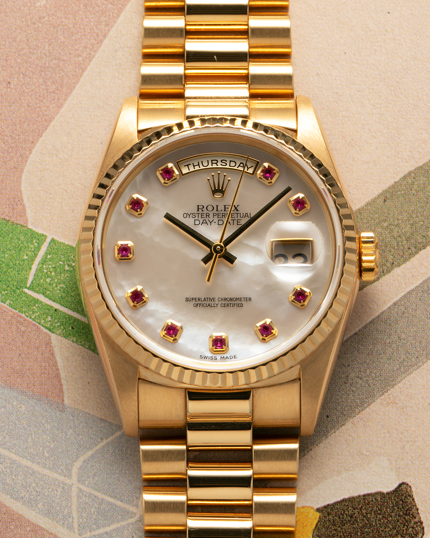 Brand: Rolex
Year: 1989
Model: Day-Date ‘Mother-of-Pearl Rubies’
Reference Number: 18238
Serial Number: L980XXX
Material: 18-carat Yellow Gold
Movement: Rolex Cal. 3155, Self-Winding
Case Dimensions: 36mm x 12mm (Lug-to-Lug 43.7mm)
Lug Width: 20mm
Bracelet: Rolex 18-carat Yellow Gold ‘8385’ Presidential Bracelet with 55B Curved End Links and Signed ‘O5’ Folding Clasp