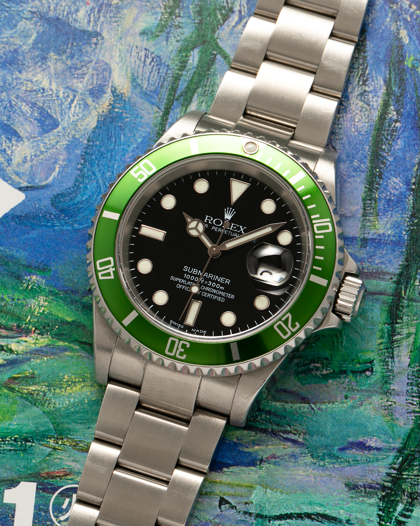 Brand: Rolex Year: 2004 Model: Submariner ‘Kermit’ Reference Number: 16610LV ‘Flat 4’ Serial Number: F Serial Material: Stainless Steel Movement: Rolex Cal. 3135, Self-Winding Case Diameter: 40mm Lug Width: 20mm Bracelet: Rolex Stainless Steel ‘93250’ Oyster Bracelet with signed ‘CL3’ Clasp