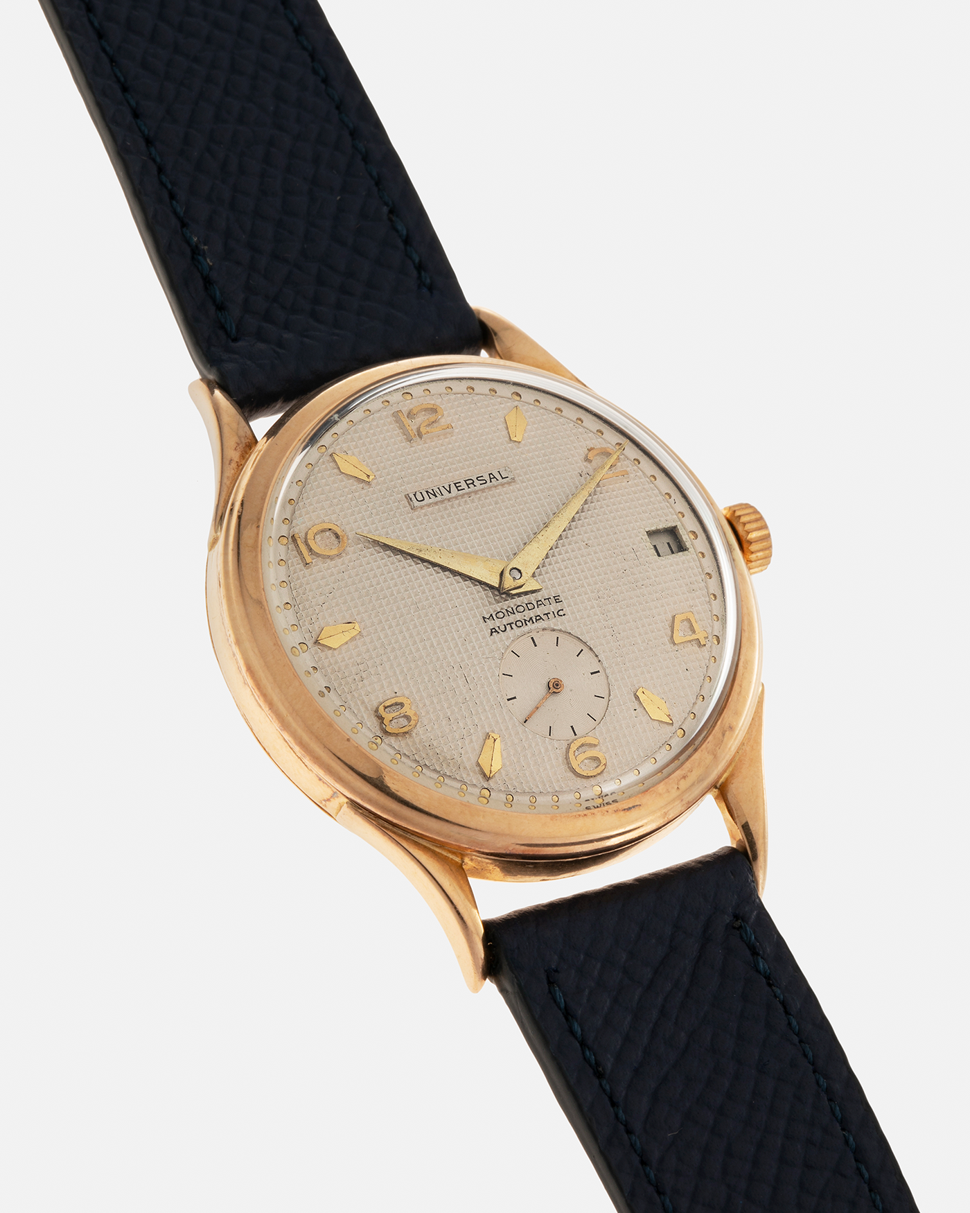 Brand: Universal Genève 
Year: 1950s
Material: 18-carat Yellow Gold
Movement: Universal Genève Cal. 138C, Bumper Self-Winding
Case Dimensions: 35mm x 10.5mm (Lug-to-Lug 43mm)
Lug Width: 18mm
Strap: Nostime Dark Navy Textured Calf Leather Strap 