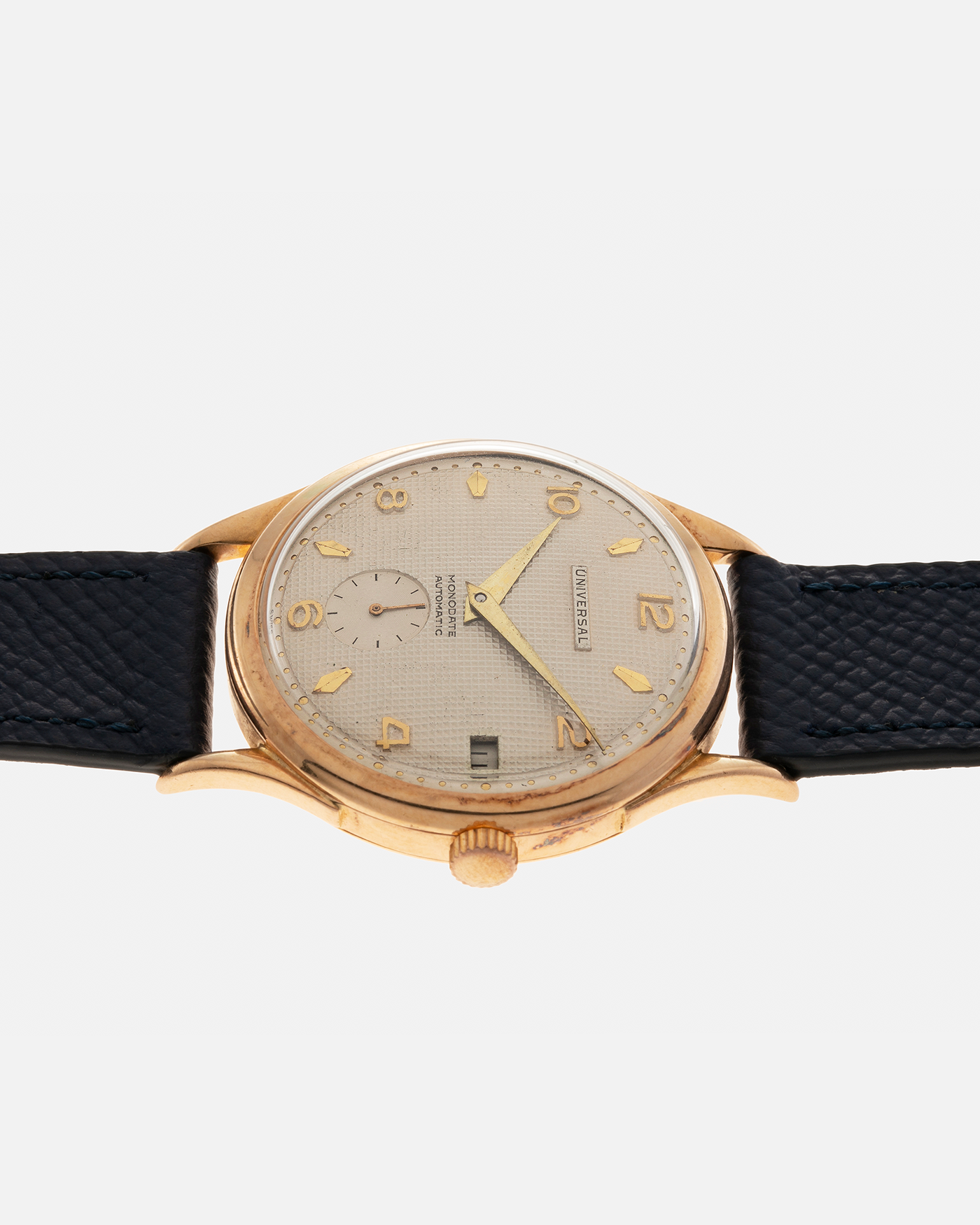 Brand: Universal Genève 
Year: 1950s
Material: 18-carat Yellow Gold
Movement: Universal Genève Cal. 138C, Bumper Self-Winding
Case Dimensions: 35mm x 10.5mm (Lug-to-Lug 43mm)
Lug Width: 18mm
Strap: Nostime Dark Navy Textured Calf Leather Strap 