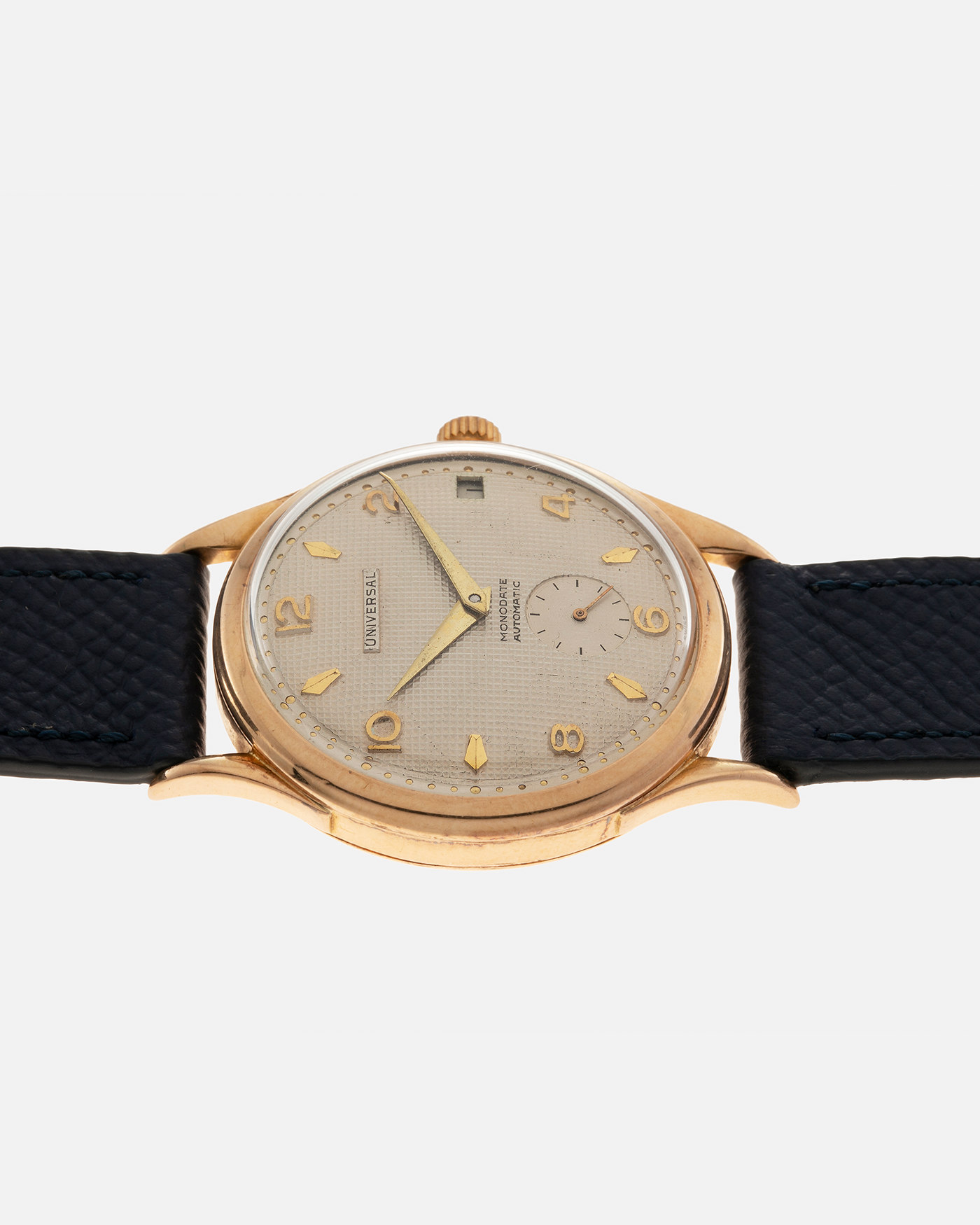 Brand: Universal Genève 
Year: 1950s
Material: 18-carat Yellow Gold
Movement: Universal Genève Cal. 138C, Bumper Self-Winding
Case Dimensions: 35mm x 10.5mm (Lug-to-Lug 43mm)
Lug Width: 18mm
Strap: Nostime Dark Navy Textured Calf Leather Strap 